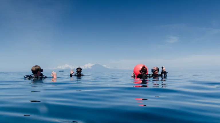Group of divers at the surface beside a marker buoy