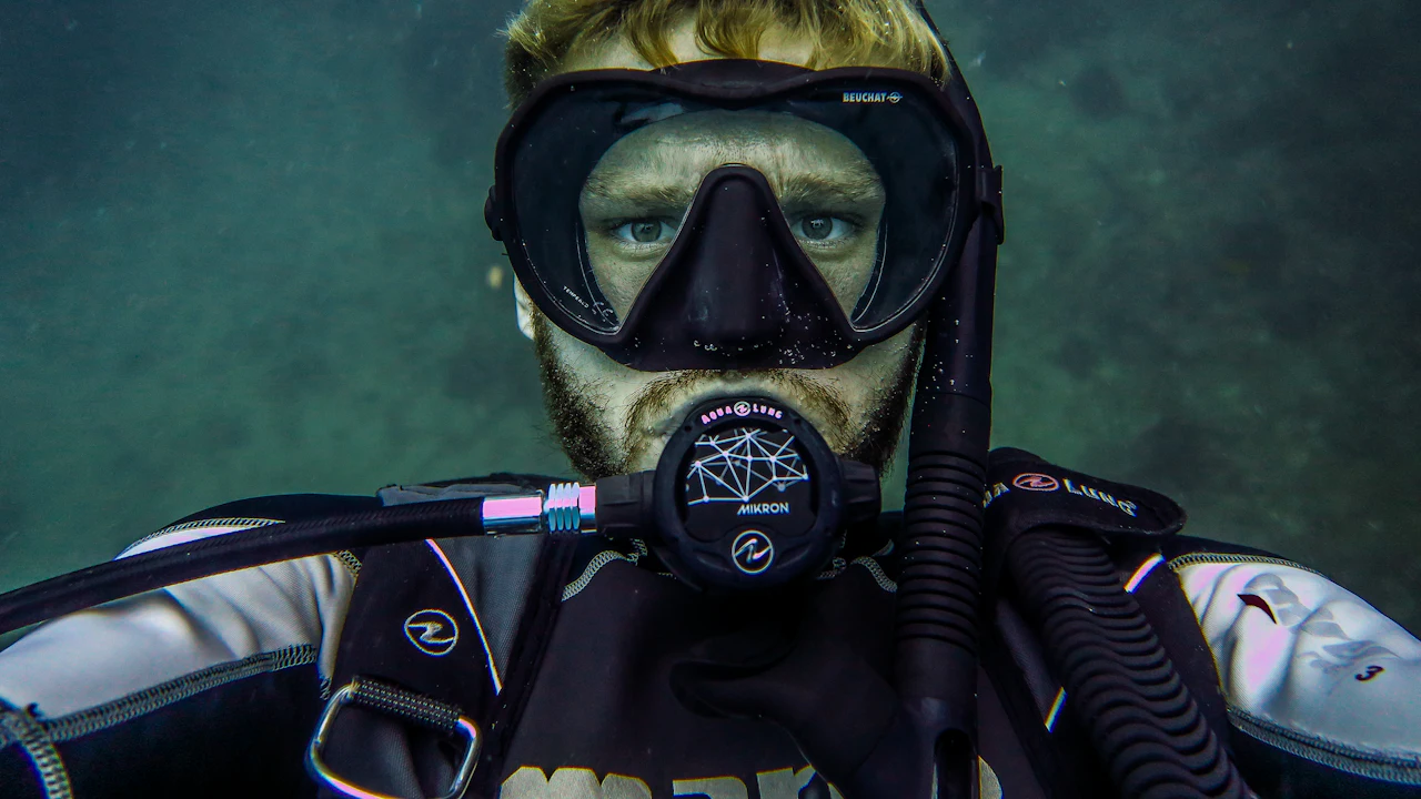 Diver in a mask with the regulator in, looking at the camera