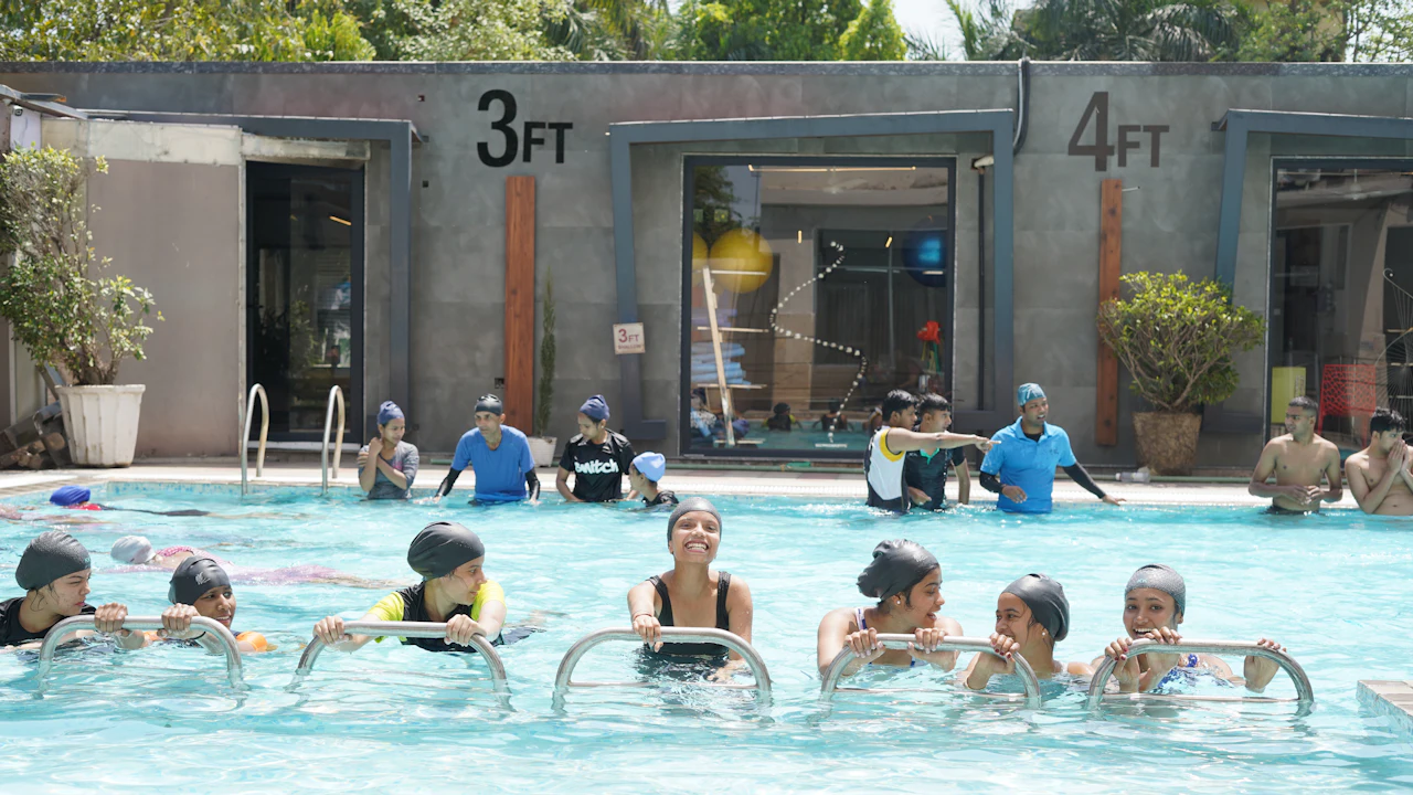 Group of students standing in a pool during a lesson