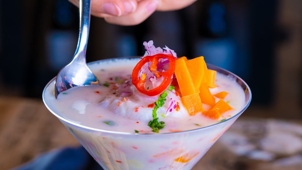 Bowl of seafood ceviche with lime, onion and cilantro on a table