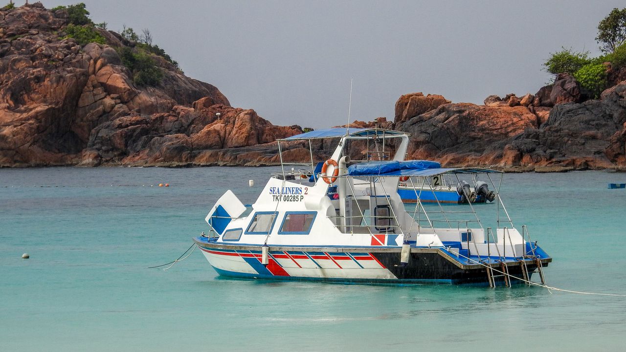 Small snorkel boat anchored in calm turquoise water on a bright morning