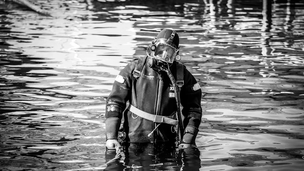 Diver in a drysuit wading into the water