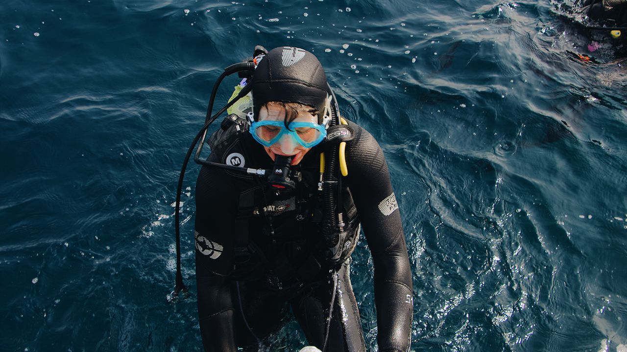 Scuba diver at the surface looking up toward the boat