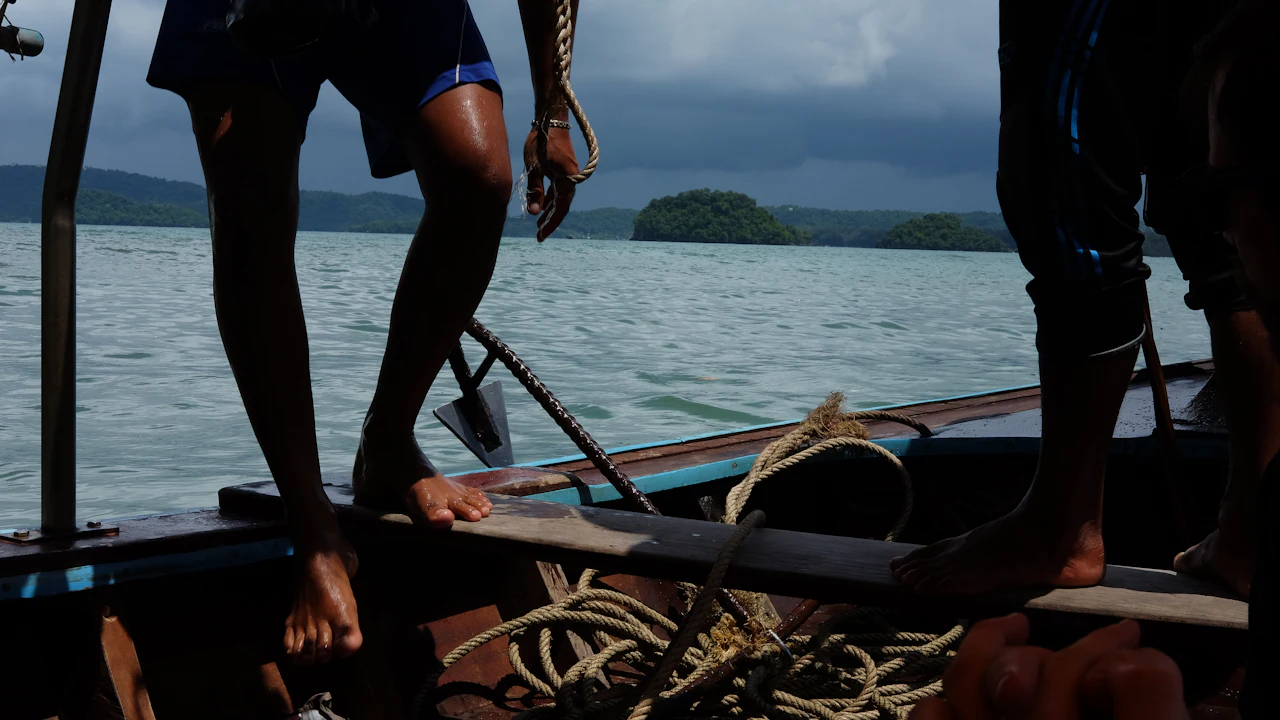People standing on a small boat with ropes