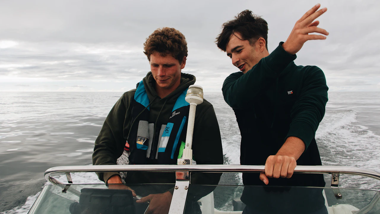 Two men in jackets on a moving boat