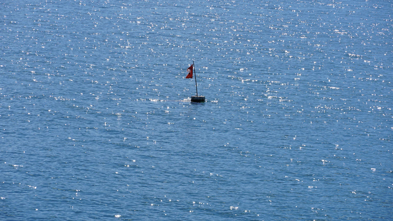Dive flag buoy floating on a calm blue sea