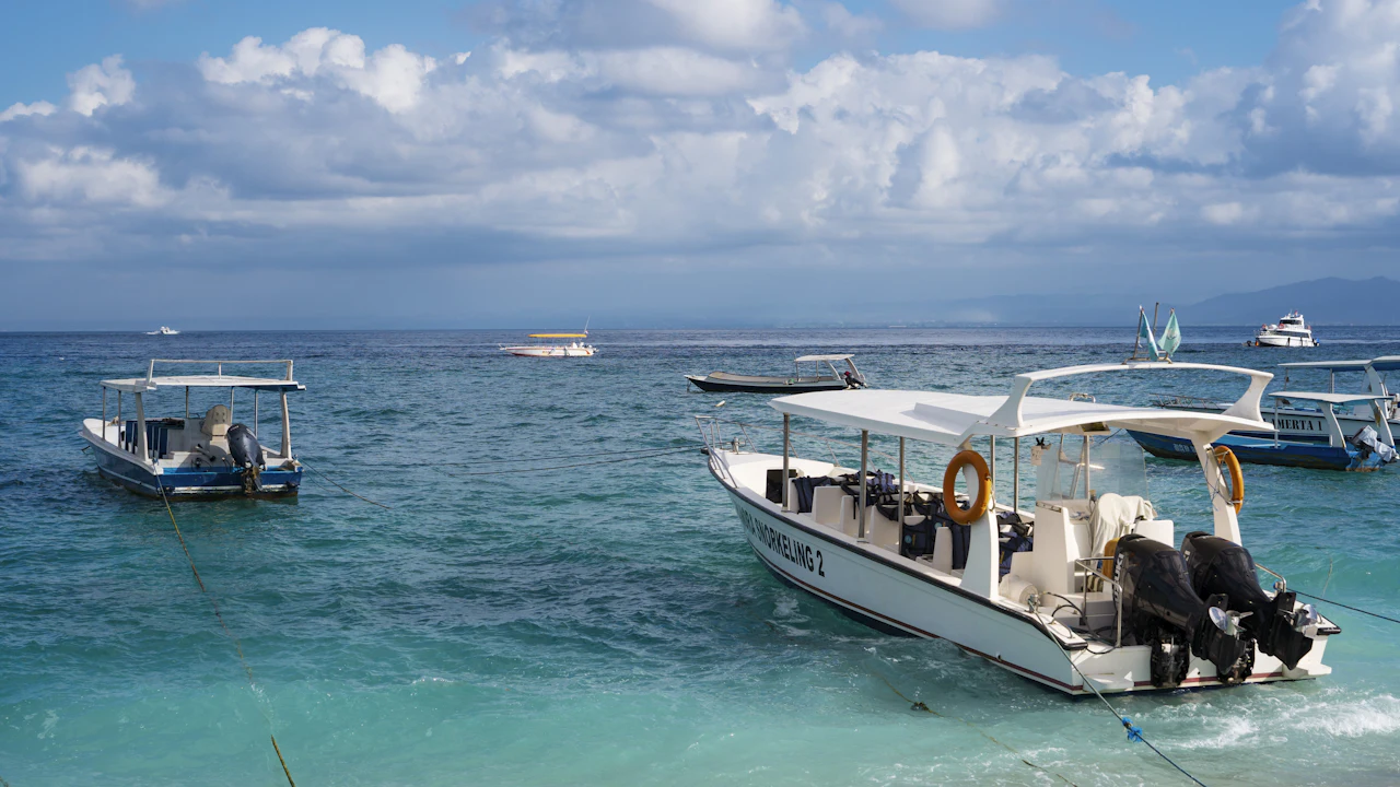 Small dive boat moored on calm turquoise water under a sunny sky