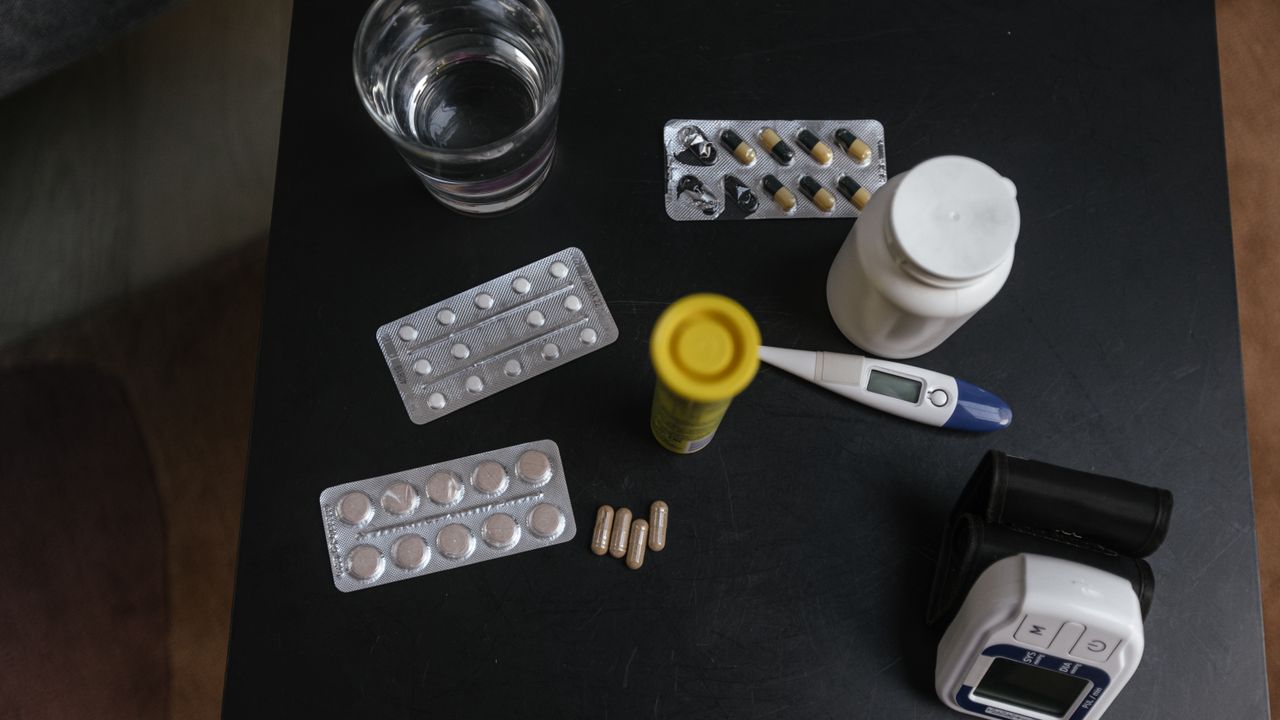 Pill packs, a thermometer and a blood pressure monitor on a table