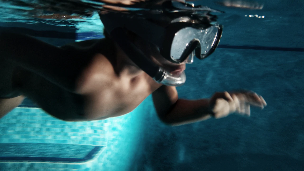 Swimmer in a pool with a diving mask on the forehead