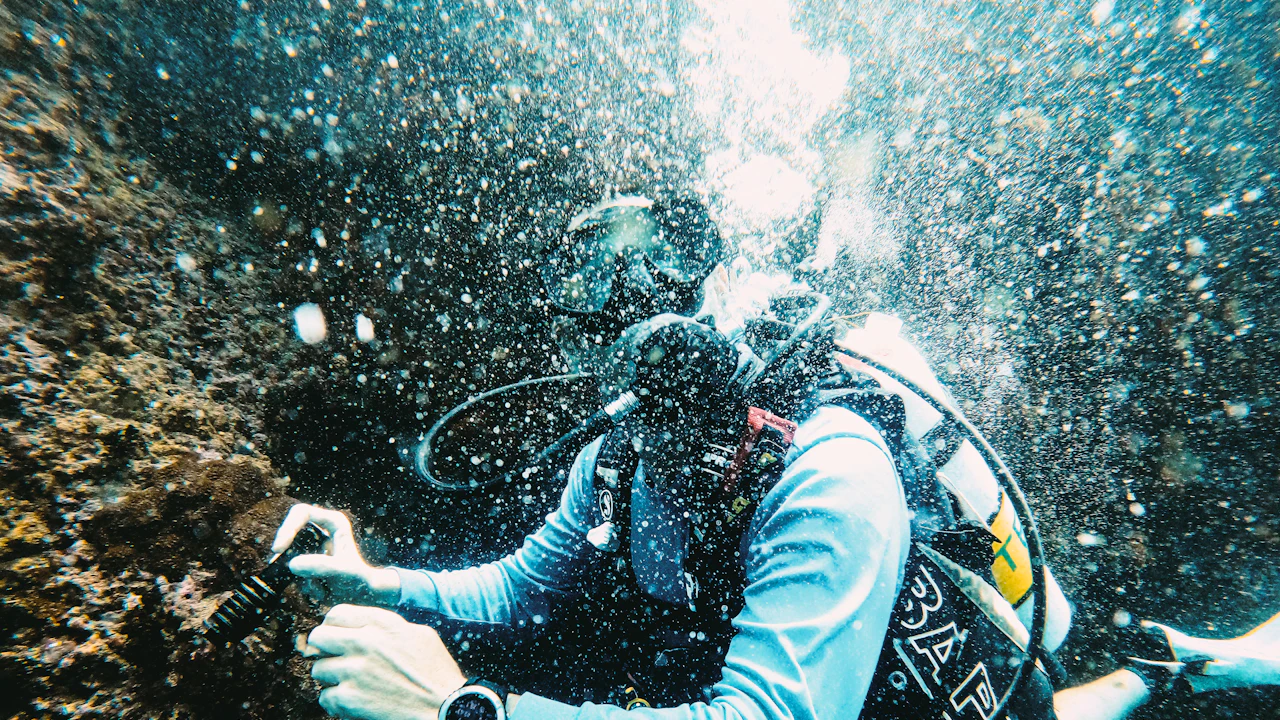 Scuba diver exploring a reef among rising bubbles