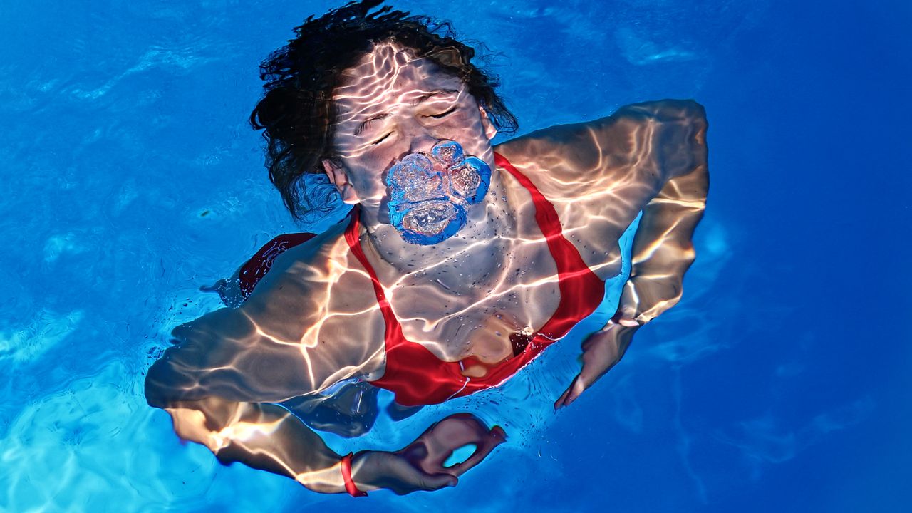 Woman swimming underwater in a pool