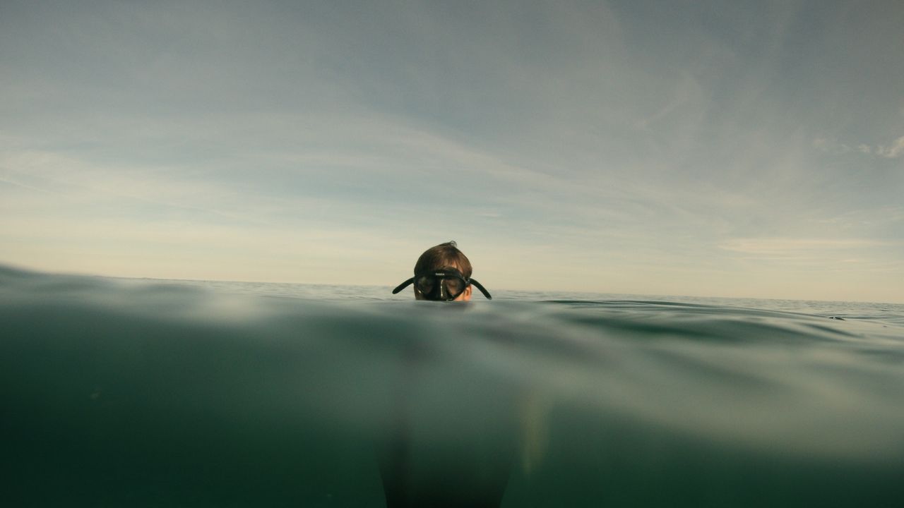 Diver floating at the surface with only the mask above water
