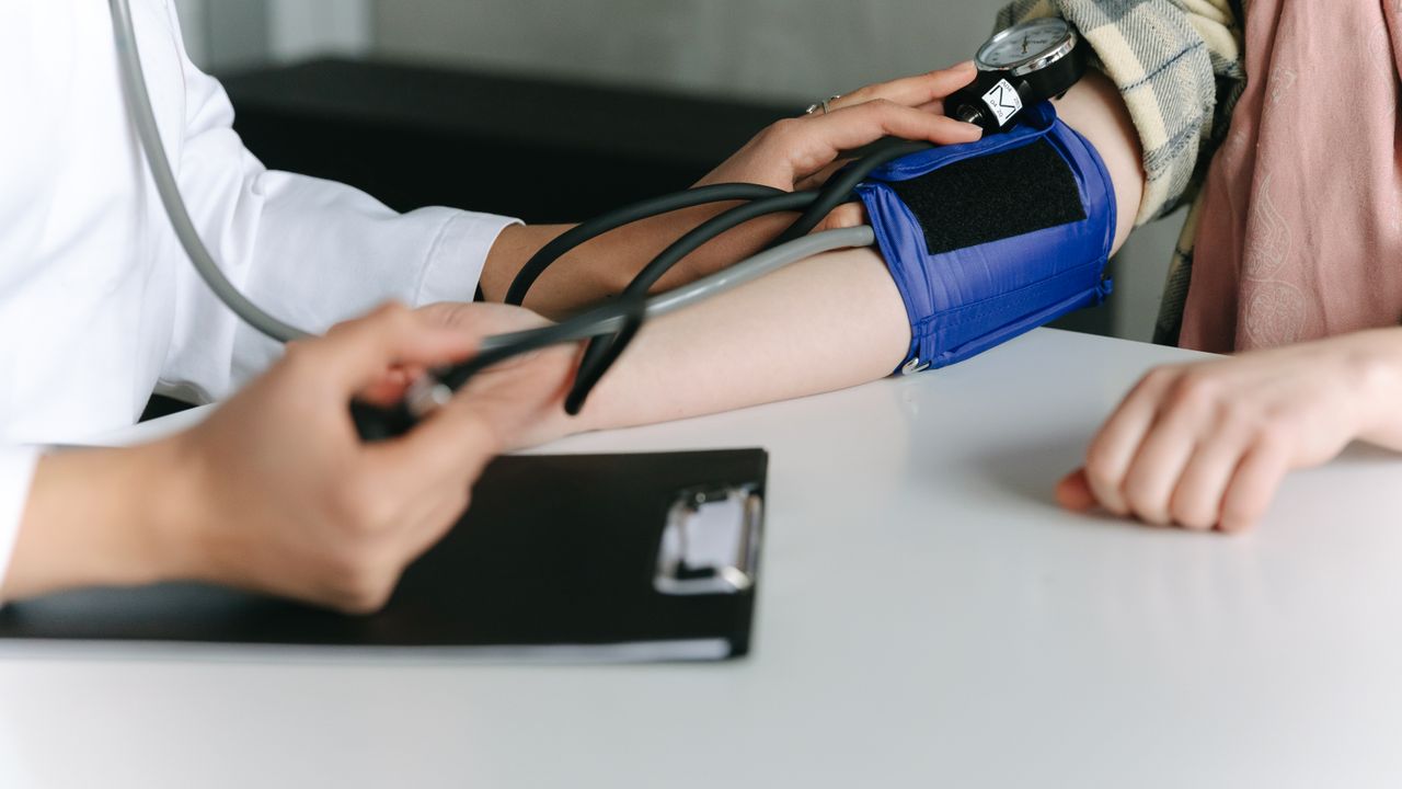 Health worker taking a patient blood pressure