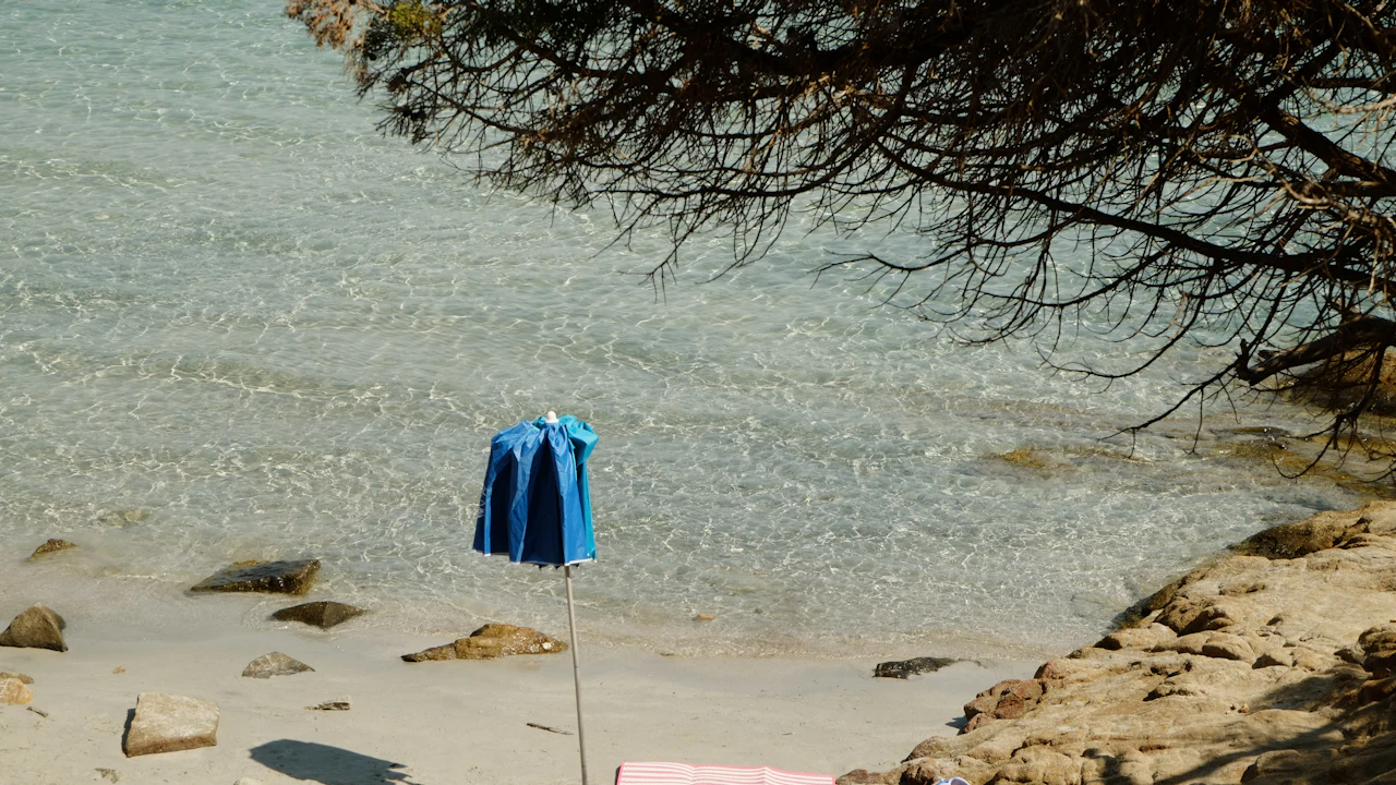 Blue towel hanging to dry beside a quiet beach