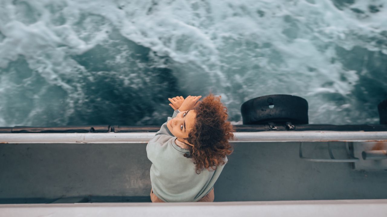 Woman on a boat looking out at the horizon over open sea