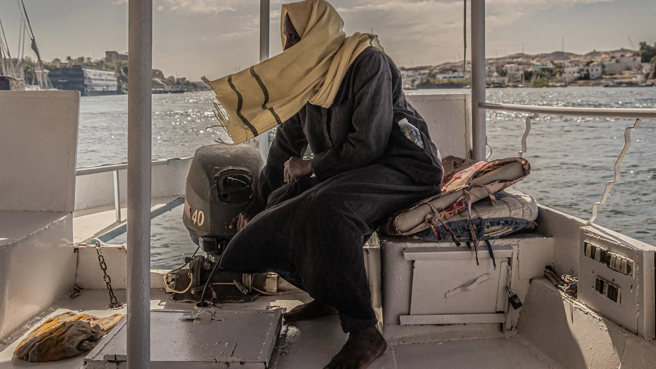 Person wrapped in a hooded towel sitting on a boat