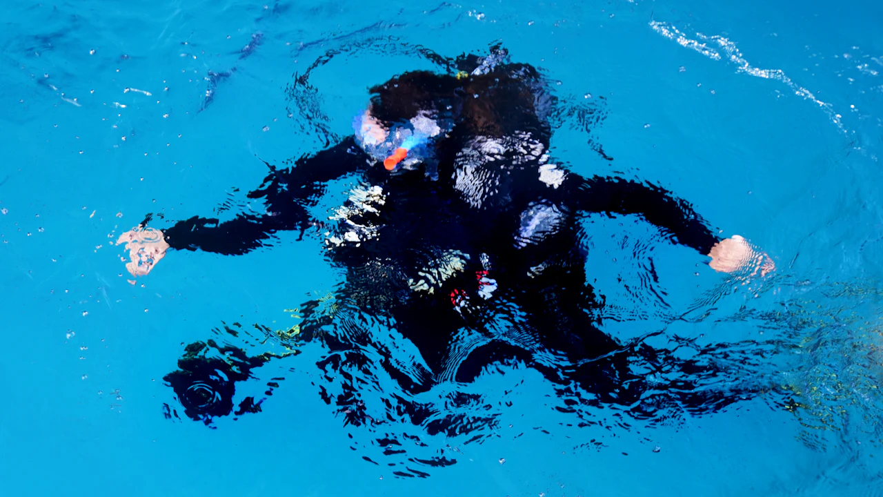 Scuba diver floating at the surface in bright blue water