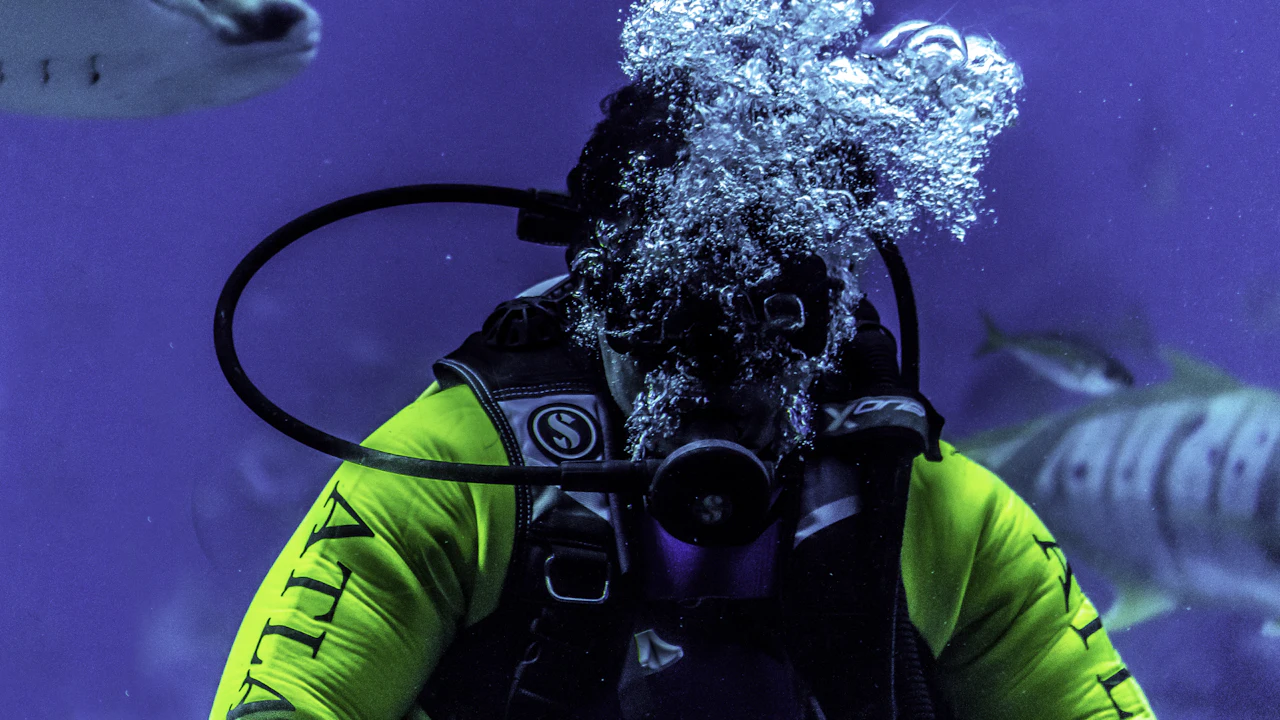 Close view of a scuba diver breathing through a regulator in blue water
