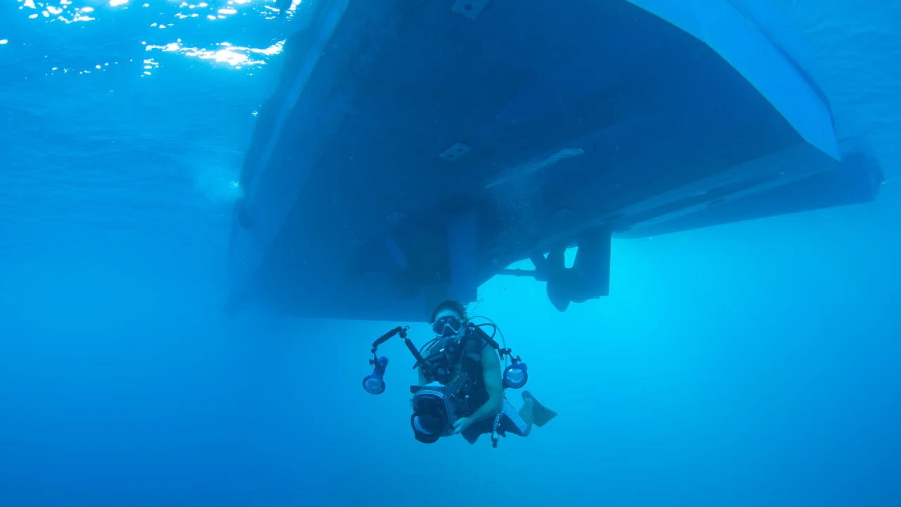 Scuba diver below the hull of a boat