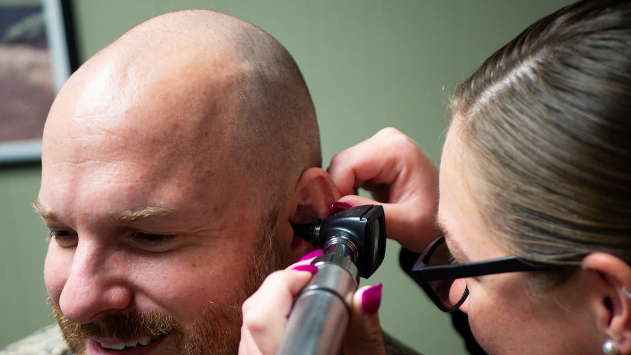 Doctor checking a patient's ear canal with an otoscope