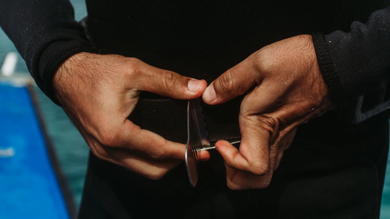 Diver's hands adjusting gear before a dive