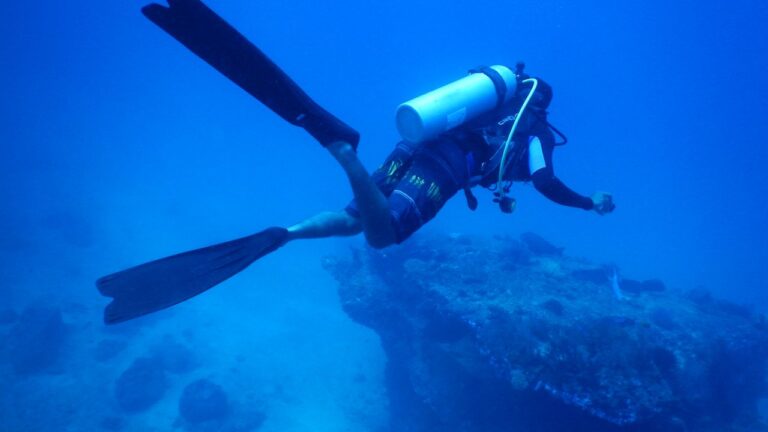 Scuba diver hovering above a reef in deep blue water