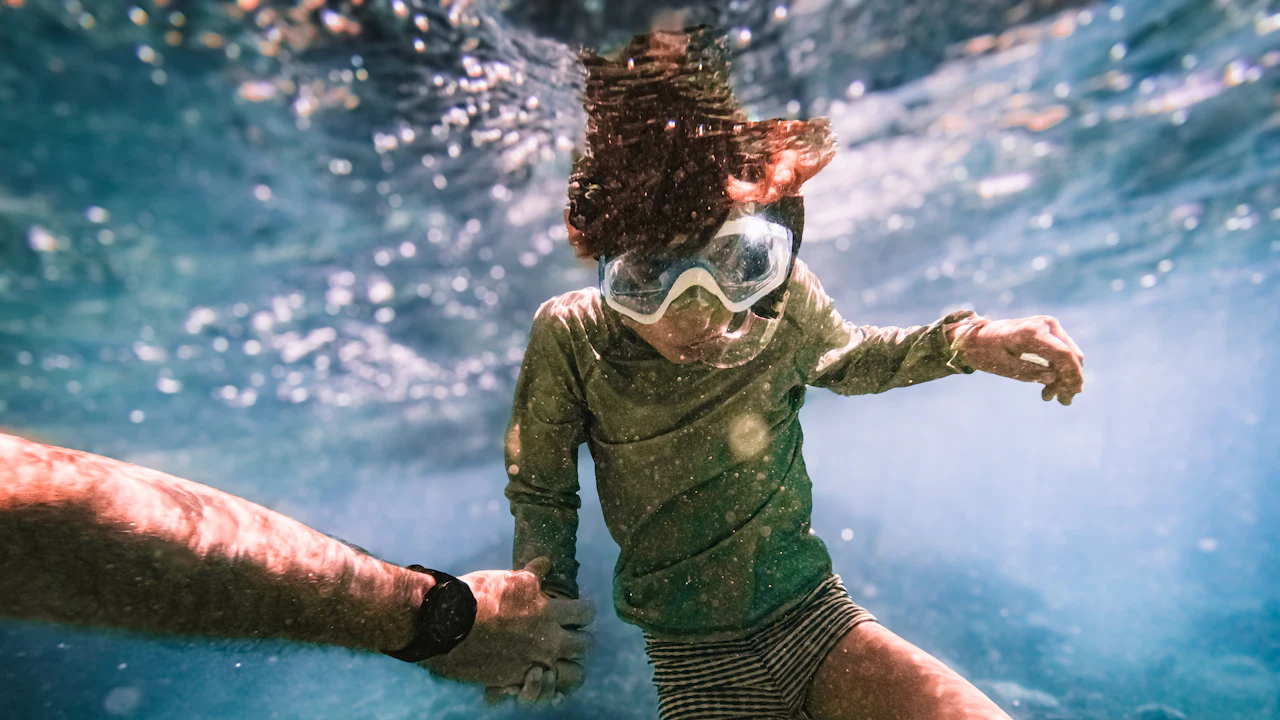 Child in a mask swimming underwater