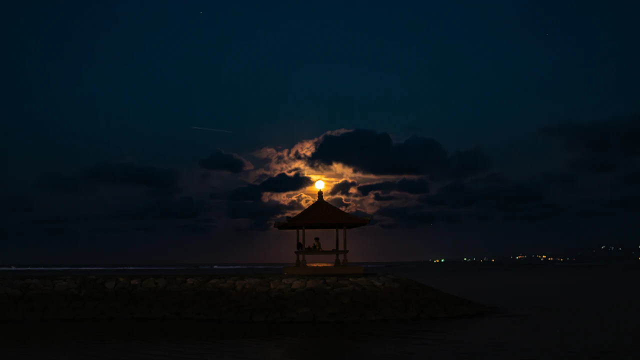 Full moon rising over a calm tropical sea at dusk